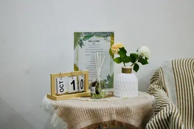 a table with a clock and a vase with flowers at Casa Neutra - A Cozy Retreat in Manila in Manila