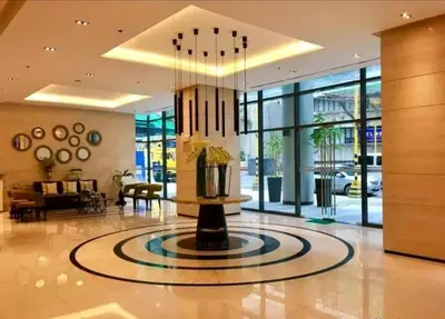 a lobby with a fountain in the middle of a building at Greenbelt Hamilton Residences by ChiKat in Manila