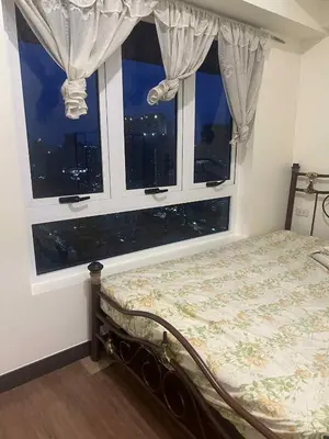 a bedroom with a bed in front of a window at Apartment 28 in Manila