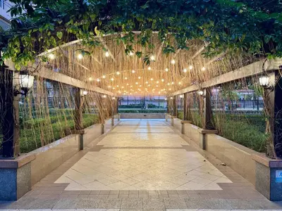 an arbor with lights and trees and a walkway at Venice Canal View with Balcony near BGC and Airport 10c in Manila