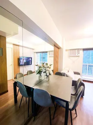 a dining room with a table and chairs at Prisma Residences - 1 Bedroom Paid Parking & Kitchen Near BGC in Manila