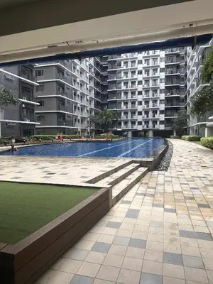 a building with a swimming pool in front of a building at JML's Condo at Shore 3 Tower 2 in Manila