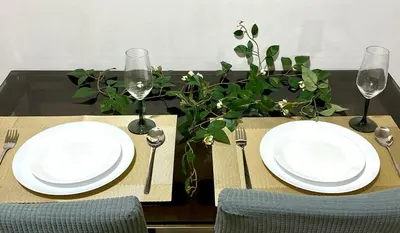 a table with two white plates and forks and glasses at Mall of Asia View Condo Living - Shore in Manila
