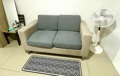a couch in a living room with a fan at Mall of Asia View Condo Living - Shore in Manila