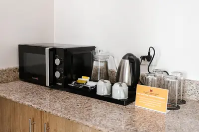 a black microwave sitting on a kitchen counter at LivStudios Manila Bay in Manila