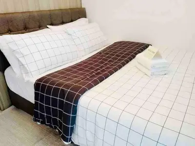 a bed with a checkered blanket on top of it at Erick 1 bedroom Shore Residence 1 in Manila