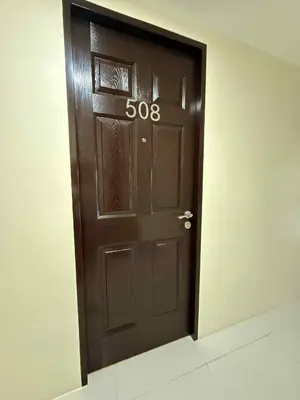 a brown door with the number on it at Urban Oasis Cozy Studio at Berkeley Suites South Forbes Nuvali in Silang