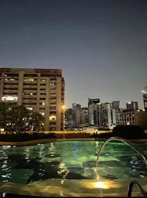 a swimming pool with a city skyline in the background at Minimalist Cozy condo in Makati,Netflix,Sauna,Pool in Manila