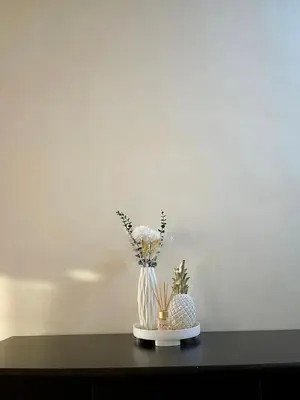 a vase with flowers in it on a table at Minimalist Cozy condo in Makati,Netflix,Sauna,Pool in Manila