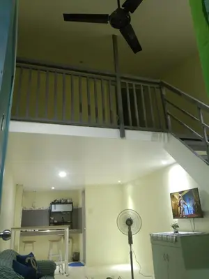 a living room with a ceiling fan and a staircase at SJ Vistacation
