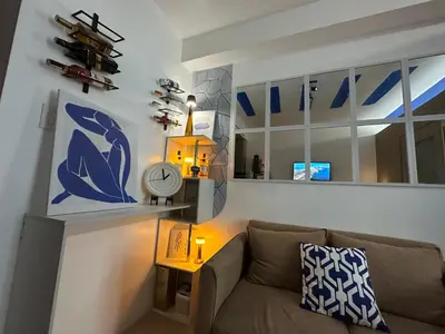 a living room with a couch and a clock at Shore Residence Casa Margarita in Manila