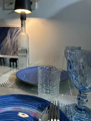 a table with plates and glasses and a bottle of wine at Shore Residence Casa Margarita in Manila