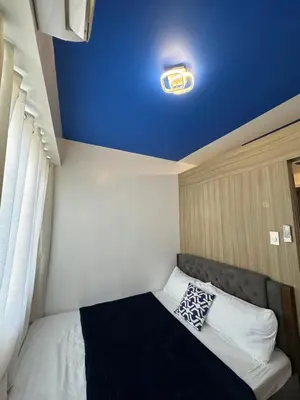 a room with a bed with a blue ceiling at Shore Residence Casa Margarita in Manila