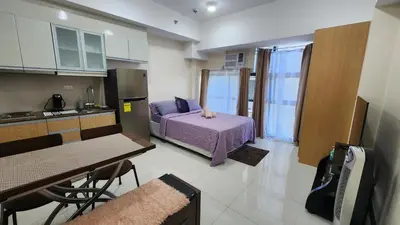 a room with a kitchen and a bed in a room at Condo unit in Taguig in Manila