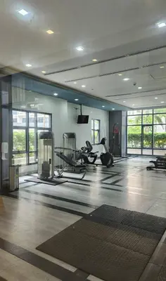 a gym with treadmills and machines in a room at Condo unit in Taguig in Manila