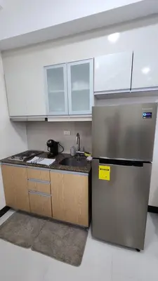 a kitchen with a sink and a refrigerator at Condo unit in Taguig in Manila