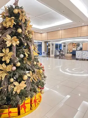 a christmas tree in the middle of a lobby at Shell Residences MOA Paul's Place in Manila