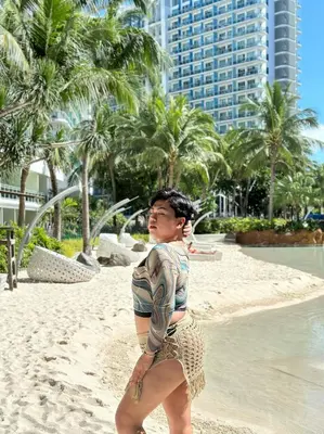a young man standing on the beach in the sand at Cityscape Staycation by H&B in Manila
