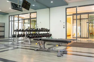 a gym with rows of exercise equipment in a room at Stingga McKinley Aesthetic Studio in Venice in Manila