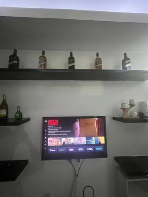 a flat screen tv hanging on a wall with shelves at JFS Home at Birch Tower 1BR in Manila