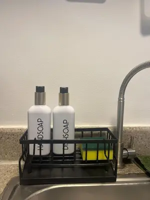 two bottles of detergent sitting in a dish rack on a sink at JFS Home at Birch Tower 1BR in Manila