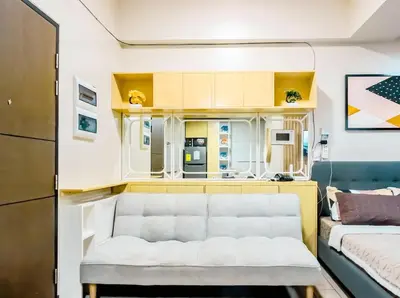 a living room with a white couch in a room at Central Makati Studio with Gym Pool and Massage Room in Manila