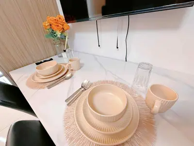 a table with plates and utensils on a table at Affordable Stay at Shore Residence near MOA by VCA Staycation in Manila
