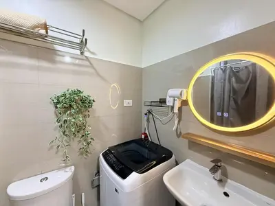 a bathroom with a white toilet and a yellow mirror at Affordable Stay at Shore Residence near MOA by VCA Staycation in Manila