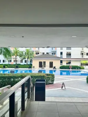 a person walking in a parking lot near a building at Cozy 1-Bedroom Staycation near NAIA & Mall of Asia in Manila
