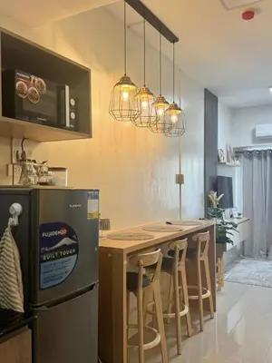 a kitchen with a table and a refrigerator at Cozy 1-Bedroom Staycation near NAIA & Mall of Asia in Manila