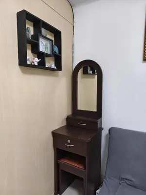 a vanity with a mirror and a chair in a room at Sea Residences Staycation SMDC Property in Manila