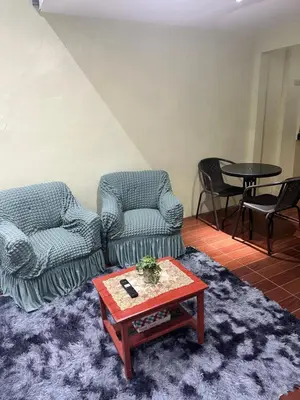 a living room with two chairs and a table at SJ Vistacation in Tanza