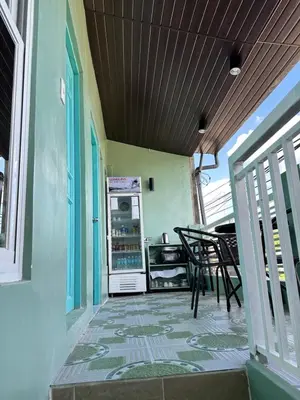 a porch with a refrigerator and a table and chairs at SJ Vistacation in Tanza
