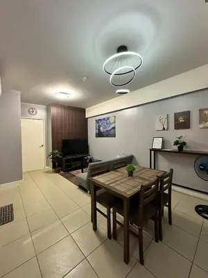 a living room with a table and a couch at Ezras Place Modern Condo with City views in Manila
