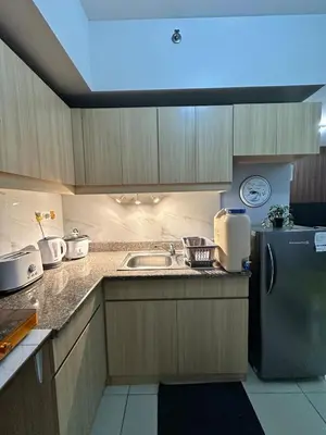 a kitchen with a sink and a refrigerator at Ezras Place Modern Condo with City views in Manila