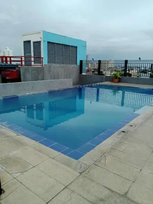 a blue swimming pool on top of a building at Affordable makati 908 deluxe in Manila