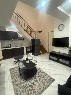a large living room with a clock on the wall at Affordable makati 908 deluxe in Manila