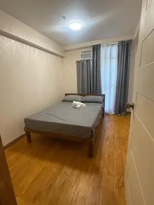a bedroom with a bed in a room with wooden floors at Affordable makati 908 deluxe in Manila