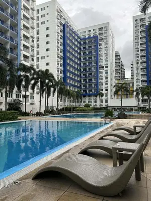 a swimming pool in a city with tall buildings at Allie's Cozy Place at Sea Residences in Manila