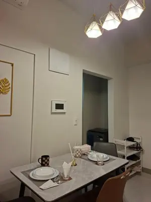a dining room with a table with plates on it at Mysuites2go24K Parksuites T2 in Manila