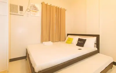 a bedroom with a bed with white sheets and pillows at UrbanView at Mherylle's Apartment near UST Manila in Manila