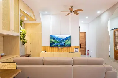 a living room with a couch and a tv at Ephram House - A-Frame Cabin Staycation with Pool, Games & BBQ For Up To 20 Guests in Bacoor
