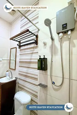 a bathroom with a shower and a toilet and a sink at Suite Haven Staycation in Sampong