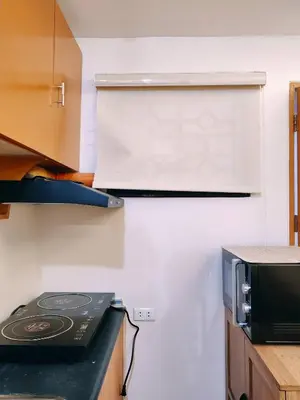 a kitchen with a stove and a microwave at Charming 2BR Condo in Cambridge with WIFI, Smart TV in Cainta