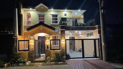 a house with a gate in front of it at night at Silang Guest house