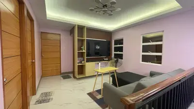 a living room with a couch and a television at Silang Guest house