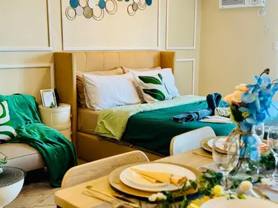 a room with a bed and a table with plates on it at Cozy Studio Near Venice Mall Netflix WIFI in Manila