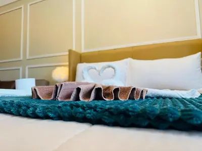 a bed with blankets and pillows on it at Cozy Studio Near Venice Mall Netflix WIFI in Manila