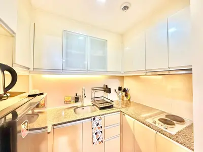 a kitchen with white cabinets and a sink at Santis Place at Eighty One Newport Blvd Across NAIA Terminal 3 in Manila