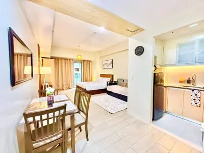 a living room with a dining room table and a kitchen at Santis Place at Eighty One Newport Blvd Across NAIA Terminal 3 in Manila